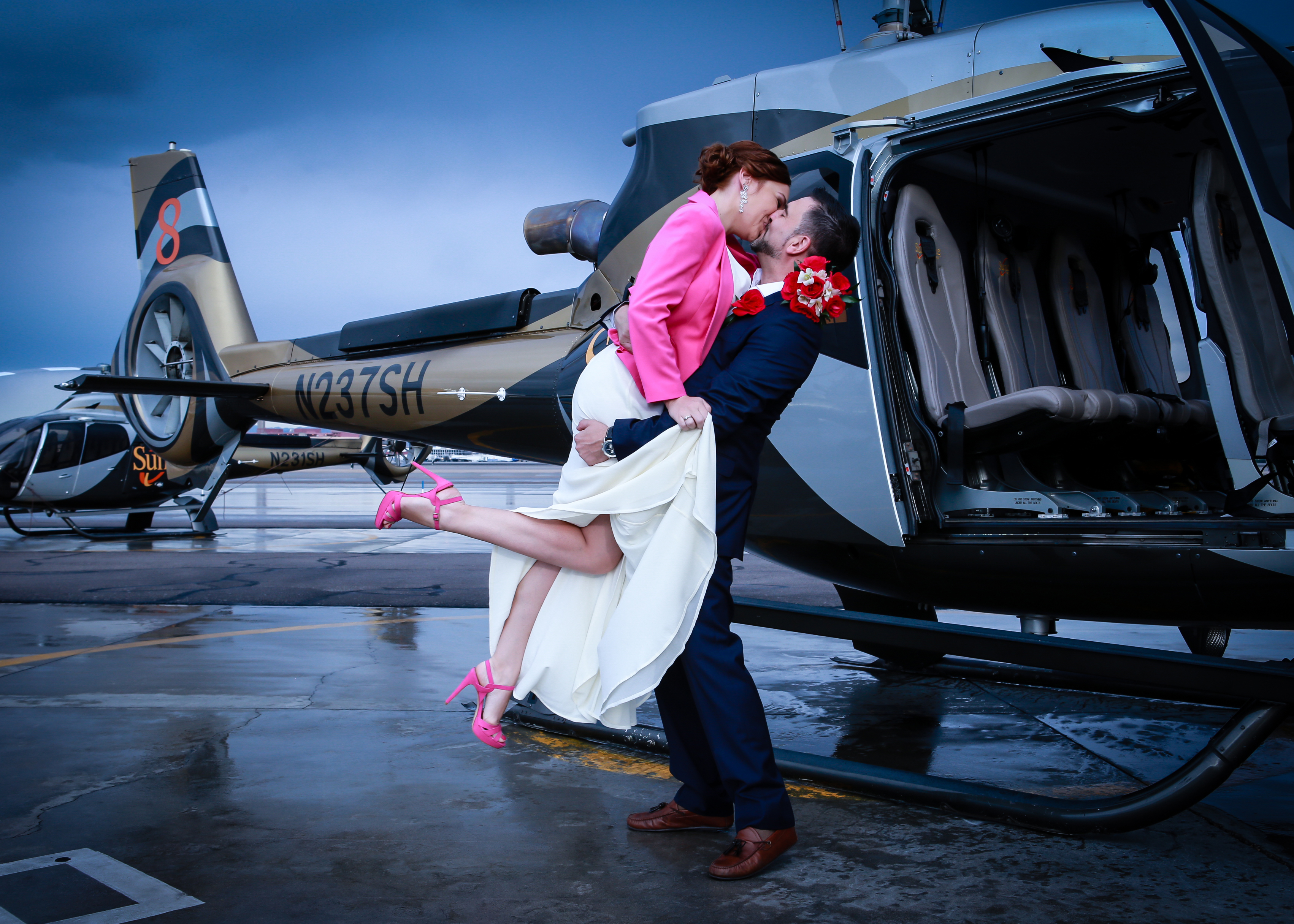 Groom embraces his wife in front of the helicopter wedding in Vegas.