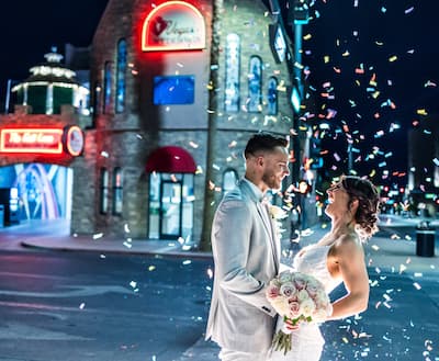 Newlyweds rejoicing while confetti pops all around them