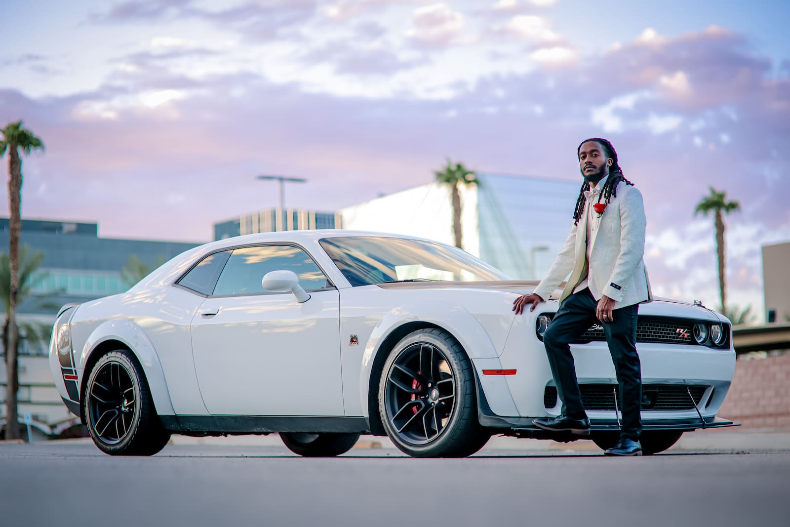 Fashionable groom dressed in white with his white sports car for the drive thru wedding in Vegas