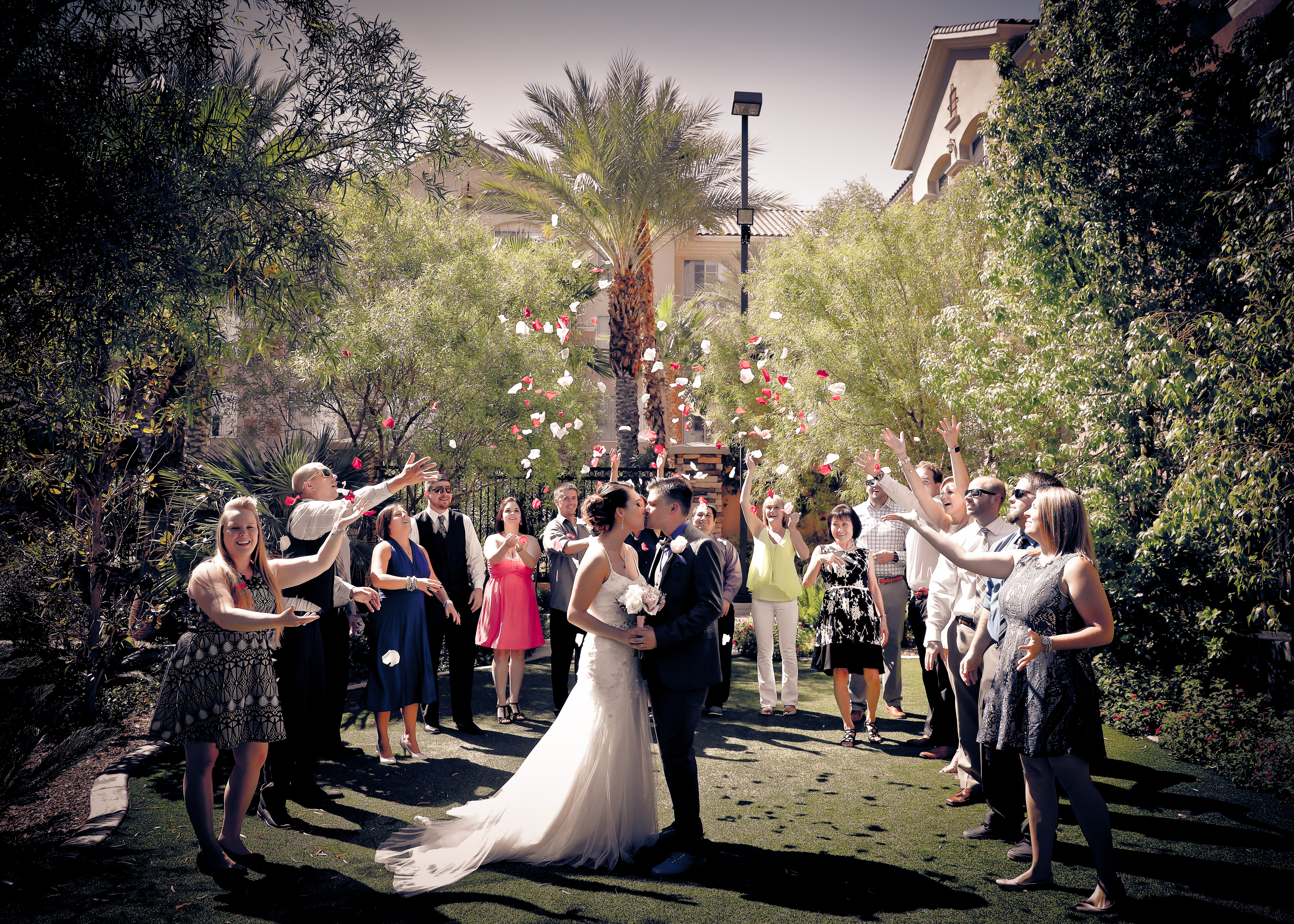 Guests circle the newlyweds and toss rose petals