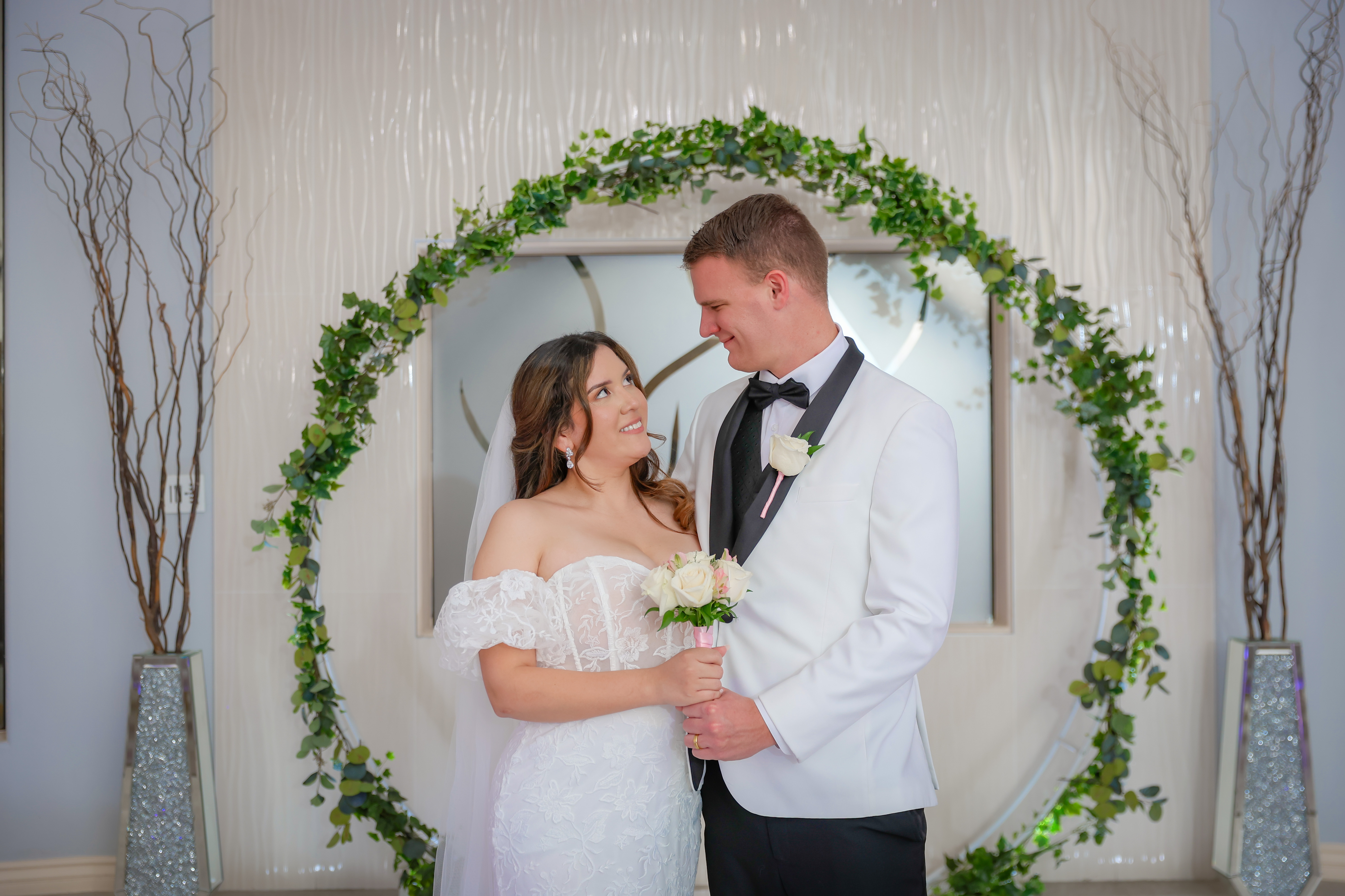 Backlit newlyweds with fog and rose petals flying 