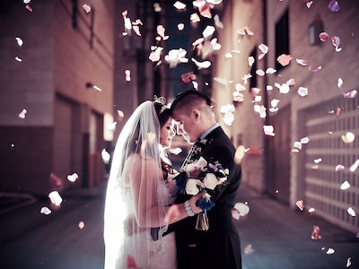 Wedding couple in a downtown Las Vegas alley with fresh rose petals cascading down all around them - Indulge Package