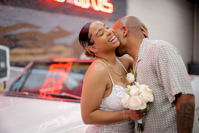 Bride laughing as her man kisses her neck in their professional photos shoot in Las Vegas