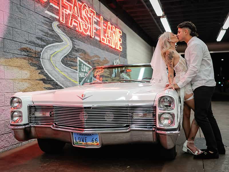 A happy couple standing in front of a Las Vegas mural on their wedding day