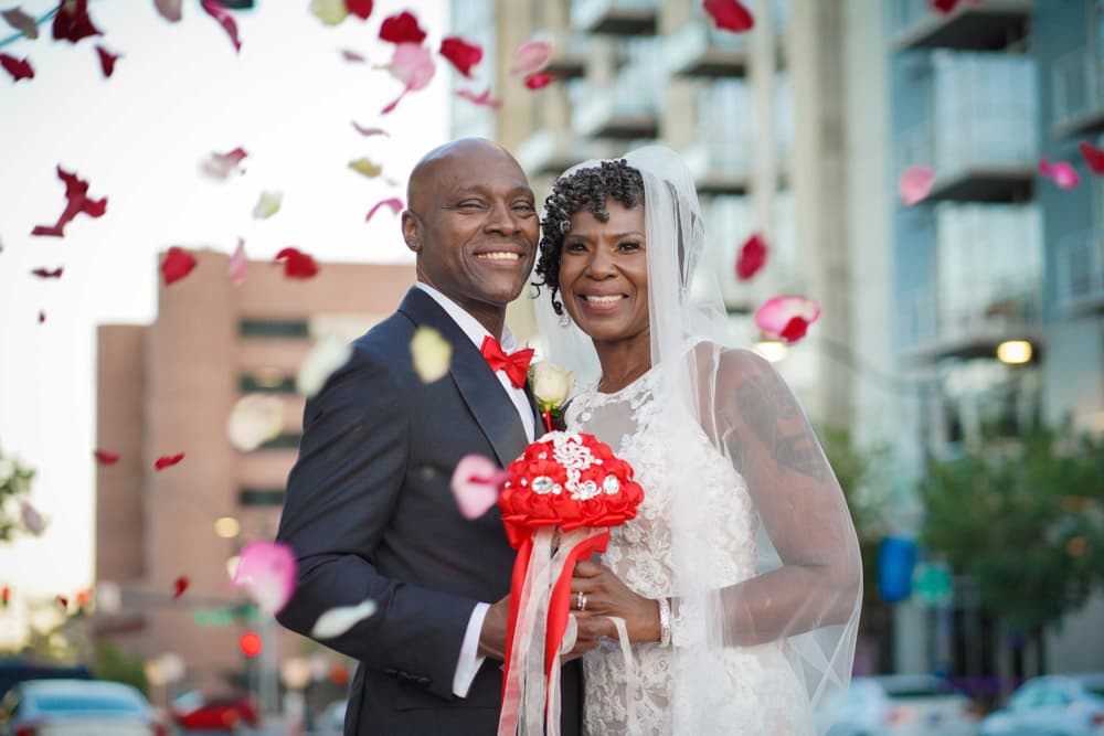 Married couple kissing their child on their vow renewal ceremony in Vegas