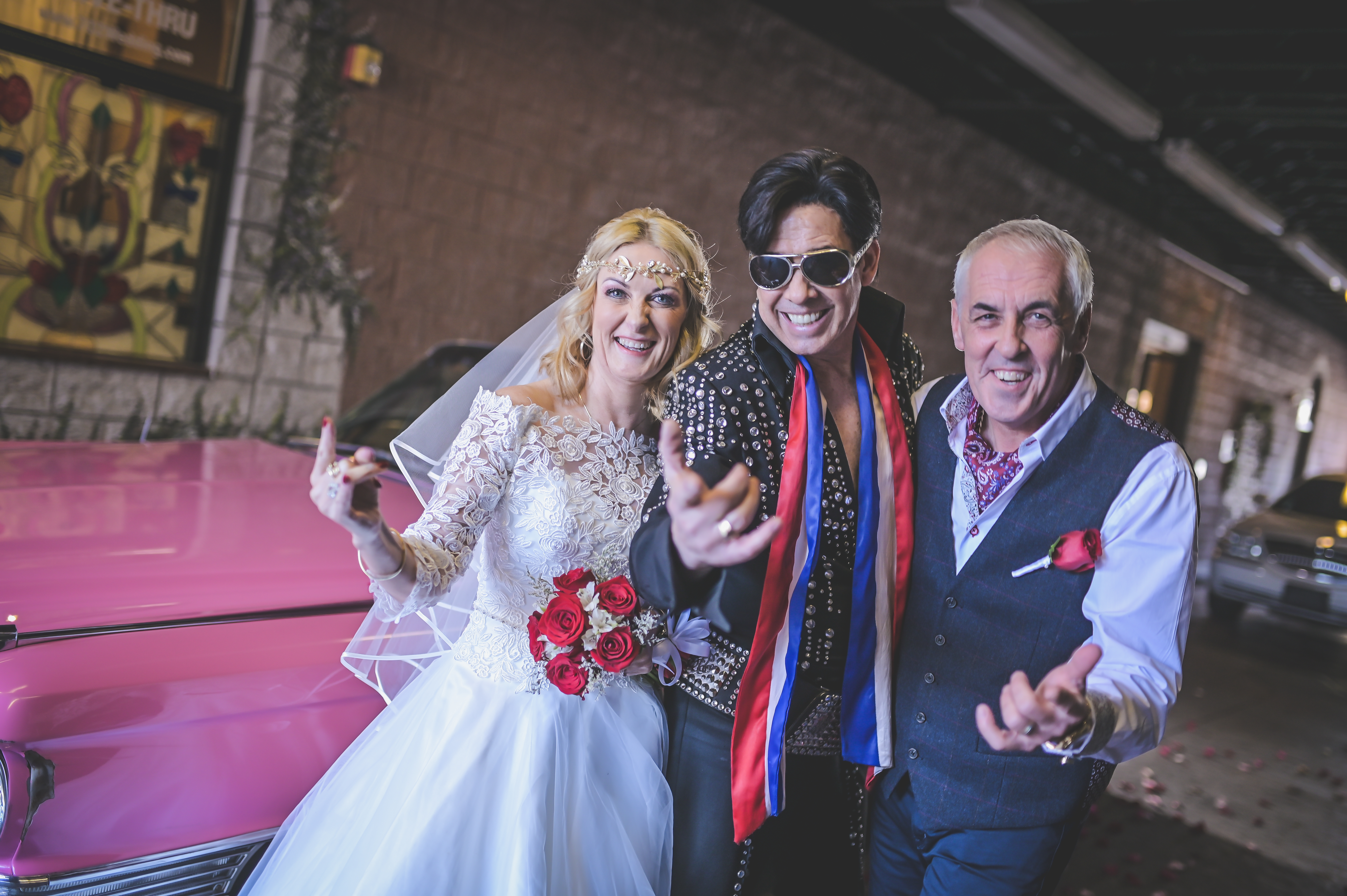 A couple standing next to Elvis on their wedding day in Vegas