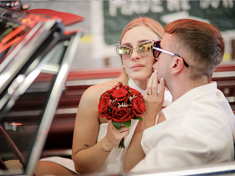 A happy couple standing in front of a Las Vegas mural on their wedding day